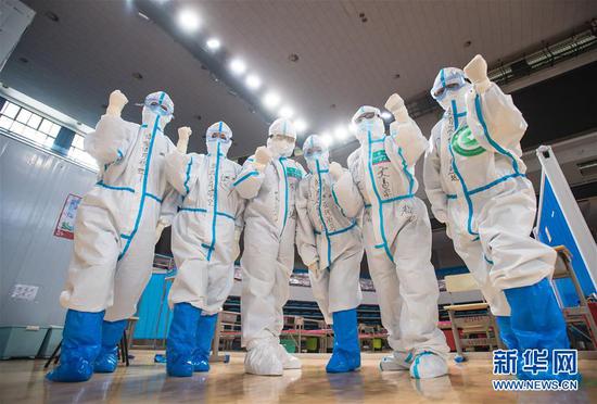 3月10日，武漢武昌方艙醫院正式休艙，醫護人員在送走新冠肺炎治愈患者后合影留念。新華社記者 肖藝九 攝