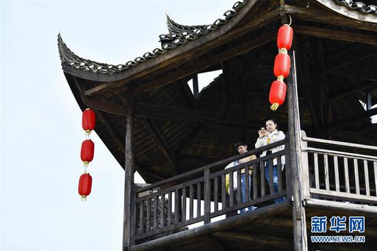  游客在重慶市武隆區黃鶯鄉復興村的觀(guān)景樓上欣賞田園景色（2019年3月28日攝）。 新華社記者 劉潺 攝