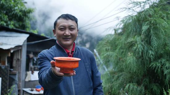  扎西巴珠展示他制作的木碗。新華網(wǎng) 旦增努布攝